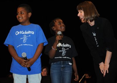 Students on stage sharing laugh with teacher