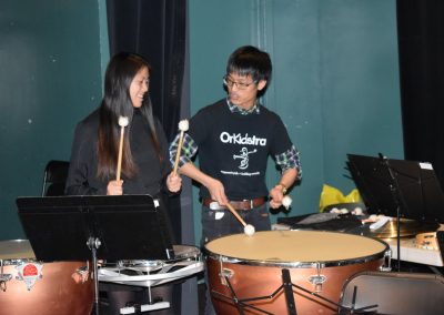 An OrKidstra student and mentor playing the drums